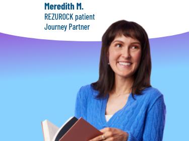 A woman holding a book and standing.